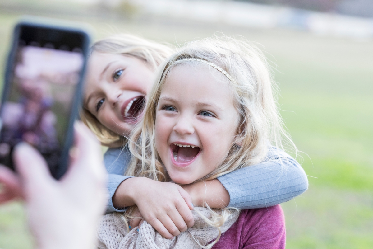 Kids taking a photo with a phone. 