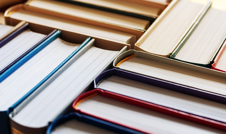 tops of books pressed together on a shelf
